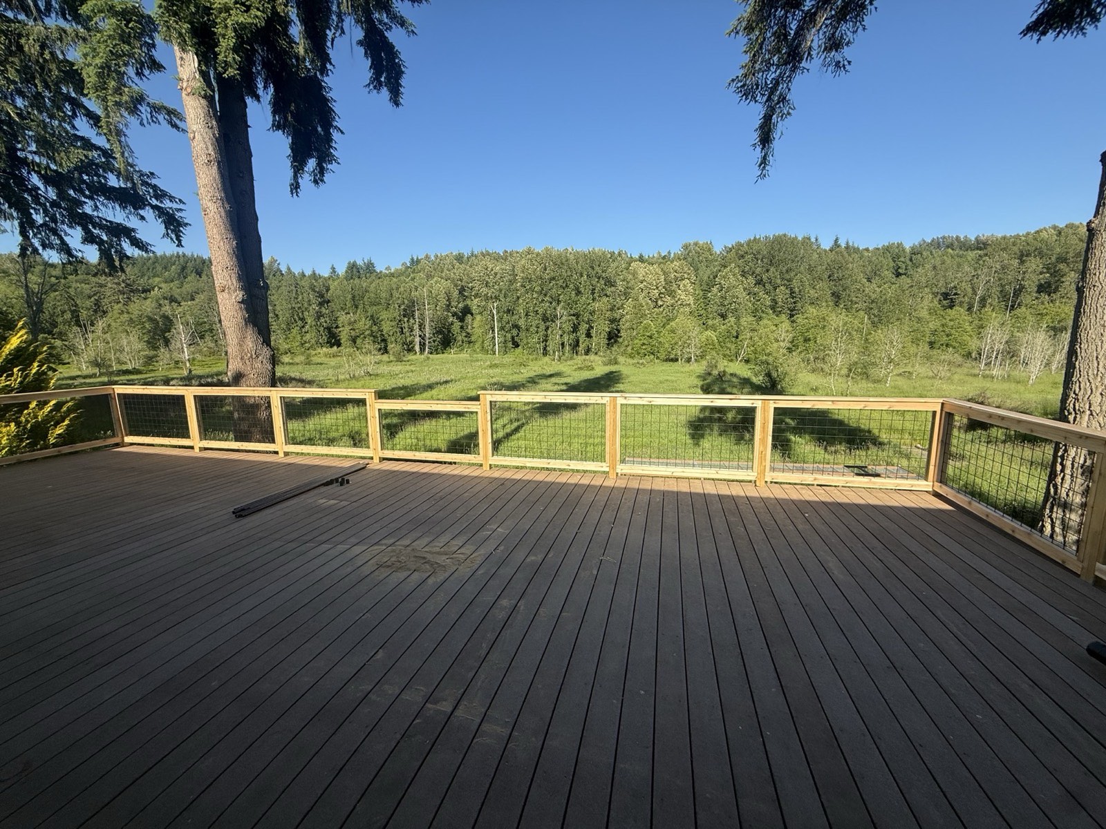 Finished deck with cable railing overlooking a forested meadow