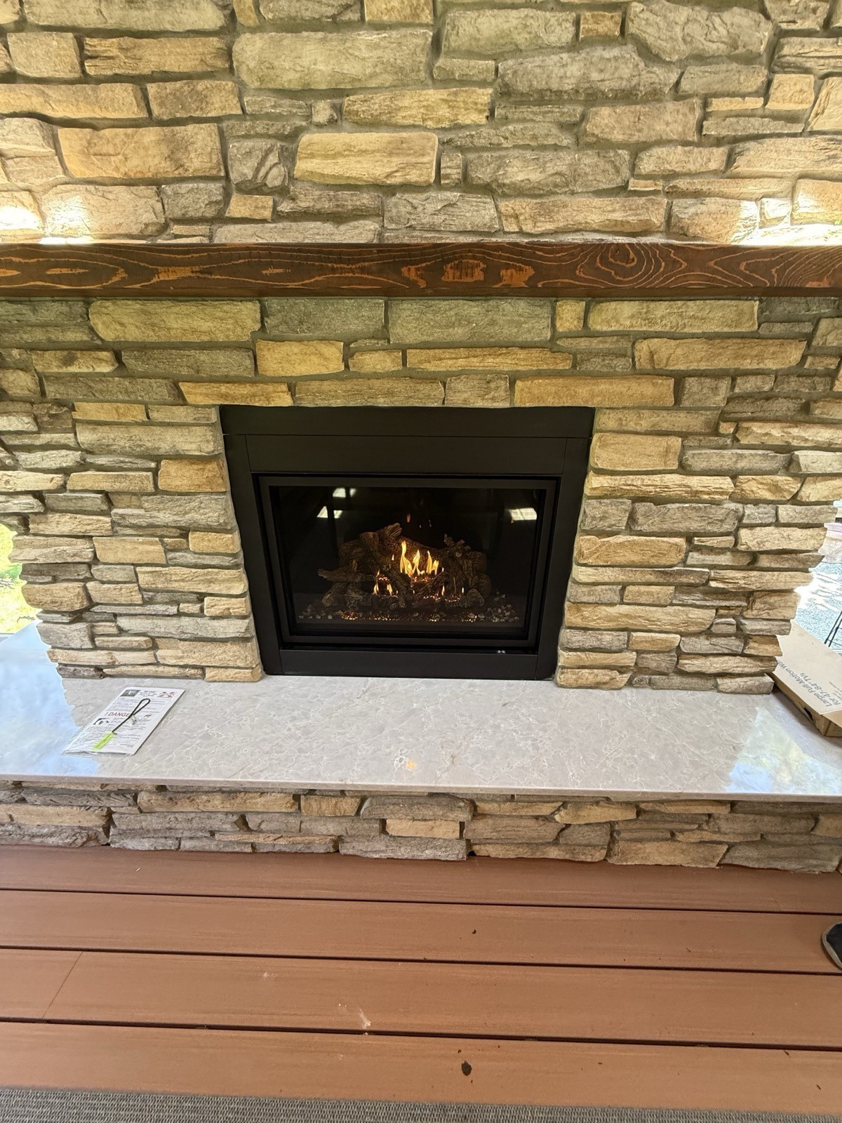 Custom stacked-stone fireplace surround with gas fireplace insert